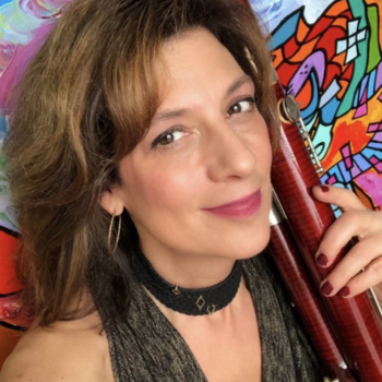 Kathleen holding her bassoon behind a colourful backdrop