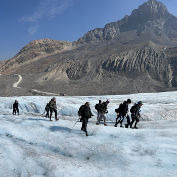 people walking across an icy glacier field