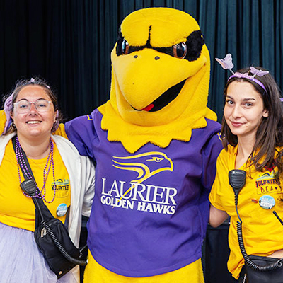 Laurier Golden Hawk with two students
